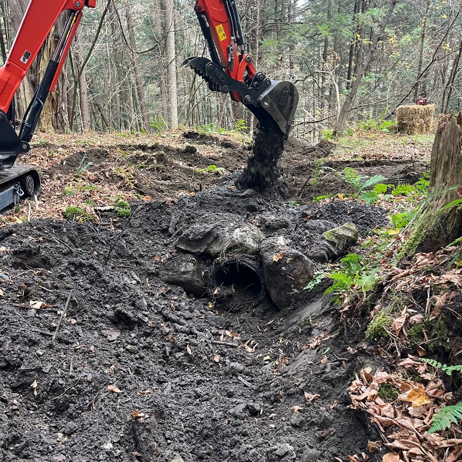 Danville S-Ski-Mo trail equipment repairing a culvert in the woods.